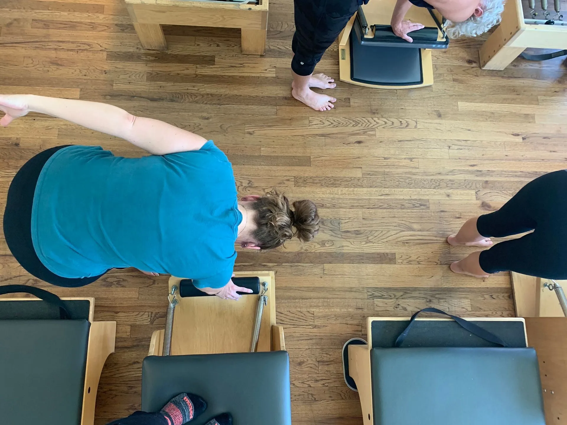 The Denver Pilates Movement studio floor: rows of reformers and towers during a class